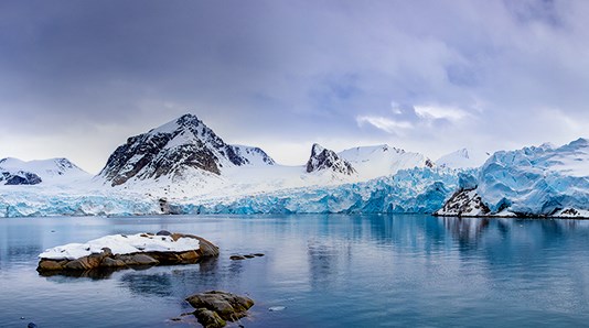 mann ser ut over landskap med spisse fjell